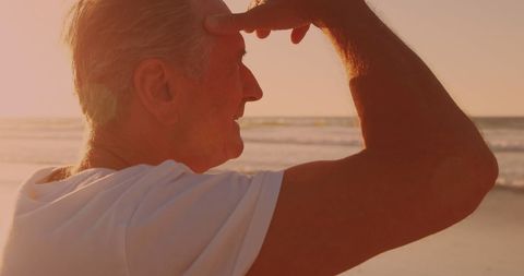 Senior Man Enjoying Serene Sunset at Tranquil Beach