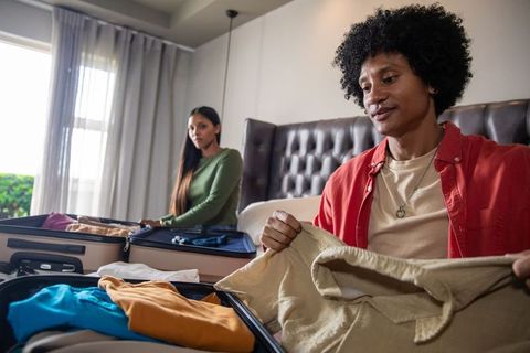 Joyful couple packing suitcases for exciting travel venture