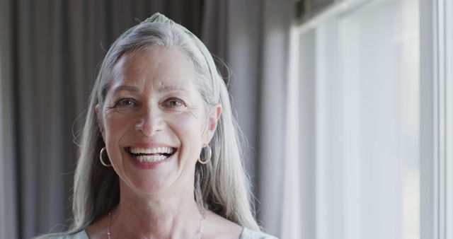 Smiling Elderly Woman in Casual Wear Near Window - Download Free Stock Images Pikwizard.com