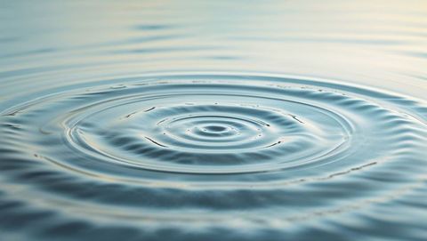 Concentric ripples creating harmony across calm pond surface