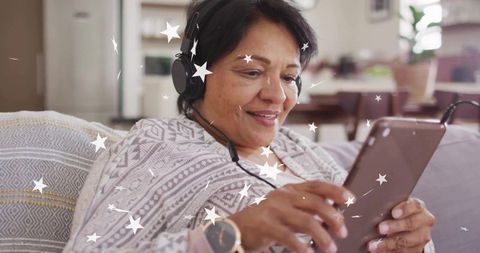 Senior Woman Relaxing with Tablet and Headphones at Home