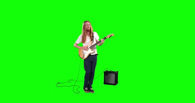 Musician with long hair playing electric guitar with amp in foreground, set against green screen background. Ideal for music-related projects, video editing, and creative content requiring isolated musicians. Perfect for adding customized backgrounds or integrating into multimedia projects.