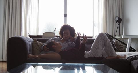 Diverse Lesbian Couple Relaxing at Home in Living Room