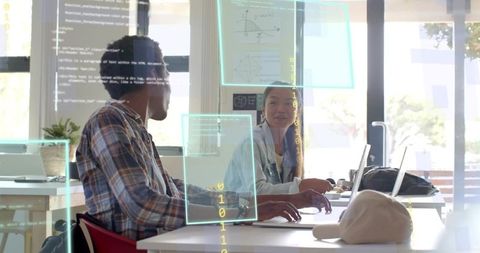 Collaborating on code in bright coworking hub with laptops and holographic overlays