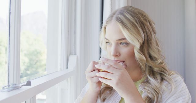 Relaxed Woman with Blonde Hair Drinking Tea by Window - Download Free Stock Images Pikwizard.com