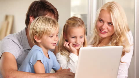 Happy Family Together Engaging with Laptop Technology