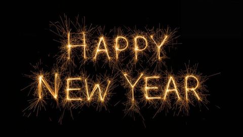 Golden Sparkler Letters Spelling HAPPY NEW YEAR on Black Background with Dynamic Sparks