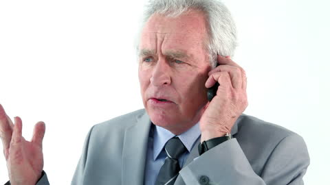 Senior Businessman Discussing on Phone with Serious Expression
