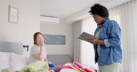 Interracial LGBTQ+ Couple Packing Luggage for Vacation at Home