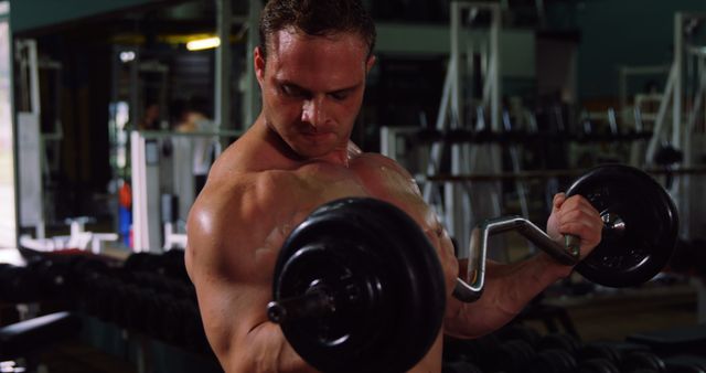 Muscular man exercising with barbell in gym 4k