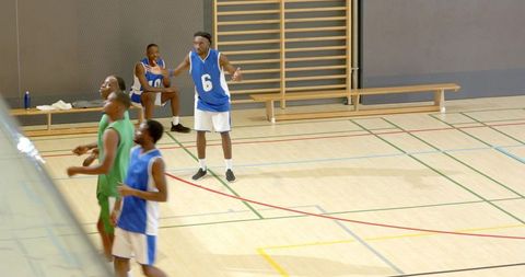 African american basketball team executing fast-paced passing and rebounding during indoor game