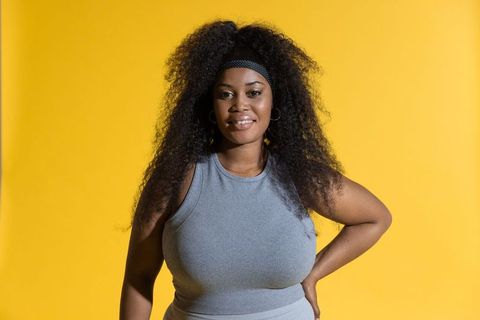 Confident african american woman posing hand-on-hip wearing gray ribbed outfit on yellow