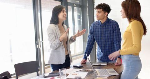 Diverse Coworkers Discussing Projects in Modern Office Meeting Room
