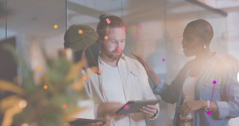 Startup team collaborating over tablet with augmented data visualization overlay