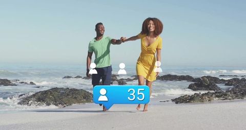 Happy Couple Walking Along Sandy Beach Receiving Social Media Notifications