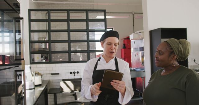 Chef Showing Menu to Restaurant Customer in Modern Kitchen - Download Free Stock Images Pikwizard.com