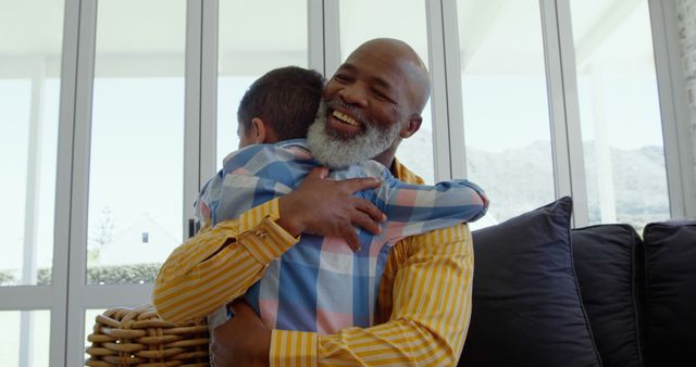 Smiling Grandfather Hugging Grandson in Bright Living Room - Download Free Stock Images Pikwizard.com