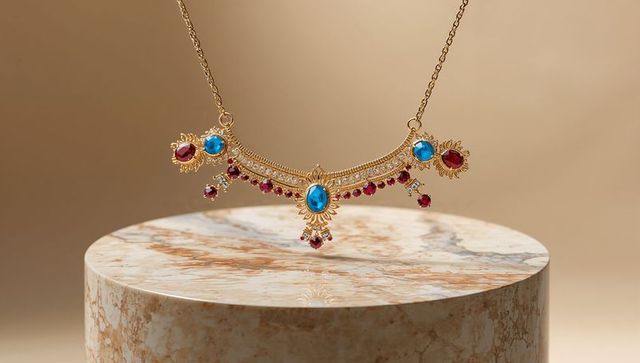 Luxury Gold Filigree Necklace with Gemstones on Marble Pedestal