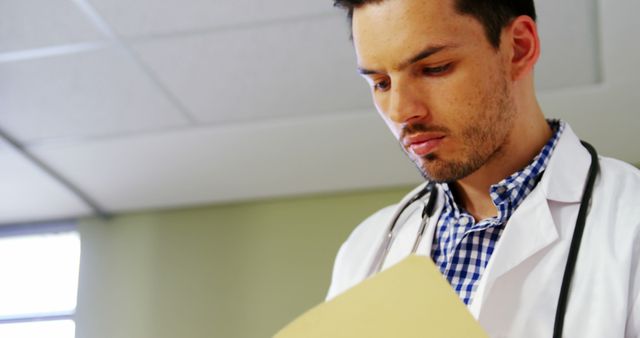 Focused Doctor Reading Medical Document in Hospital Room - Download Free Stock Images Pikwizard.com