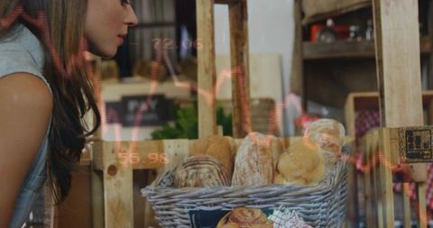Young woman checking artisanal bread in wicker basket at rustic farmers market display