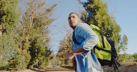 young man hiking on sunny nature trail with backpack - Download Free Stock Images Pikwizard.com