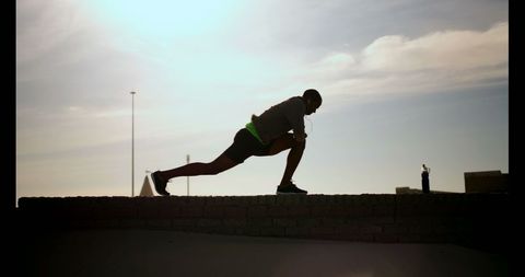 Silhouette of Man Stretching by the Beach at Sunrise - Download Free Stock Images Pikwizard.com