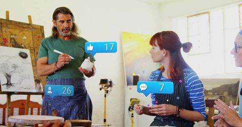 Art teacher demonstrates ceramic painting to engaged students