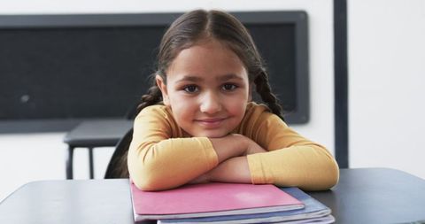 Young student relaxing with notebook in classroom environment