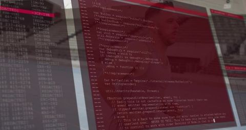 Multimonitor workstation showing red terminal code reflecting focused developer in office