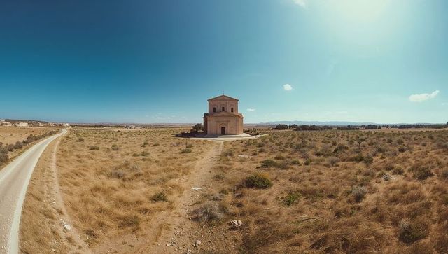 Standing stone chapel in arid grassland with winding path leading to isolated landmark