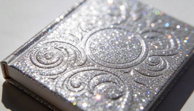 Sparkling silver glitter journal with embossed swirl design and white page edges