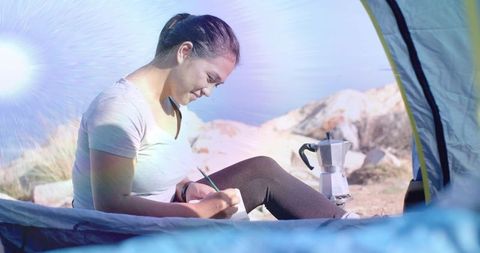 Relaxed Camper Writing in Journal at Scenic Mountain Campsite