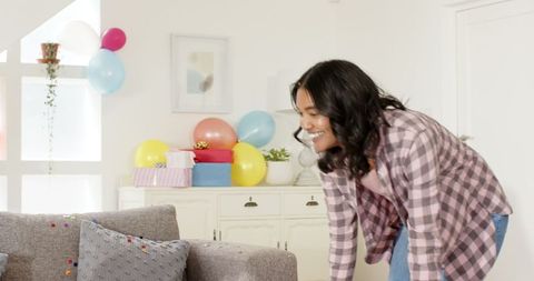 Woman tidying confetti at home after celebration