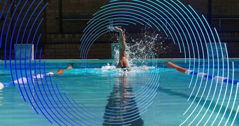 Competitive swimmer pulling through lap pool, splashing water and reflecting motion