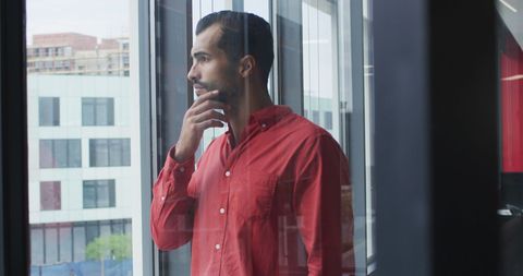 Thoughtful Businessman Viewing Cityscape from Office Window