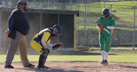 Umpire Signaling While Catcher Crouching and Batter Adjusting Bat at Home Plate
