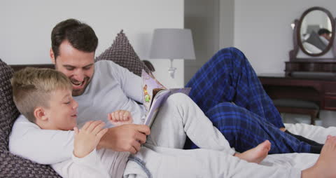 Father and Son Bonding with Storytime on Bed