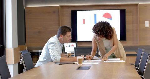 Colleagues Analyzing Financial Charts in Meeting Room