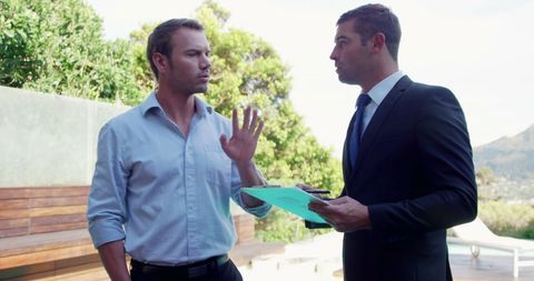 Businessmen Engaging in Serious Discussion Outdoors