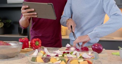 Friends Collaborating to Prepare Healthy Vegetable Bake in Modern Kitchen