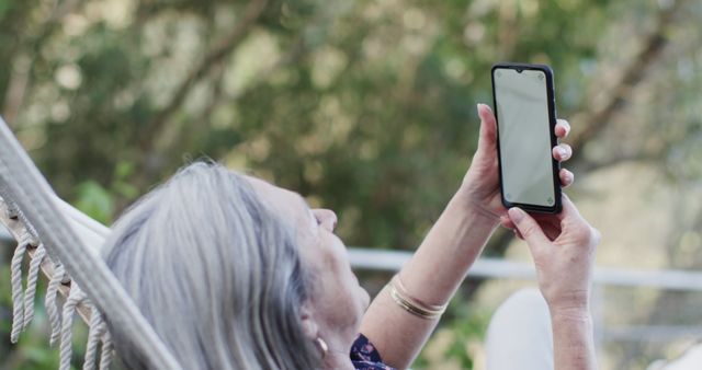 Senior Woman Relaxing in Hammock Using Smartphone Outdoors - Download Free Stock Images Pikwizard.com