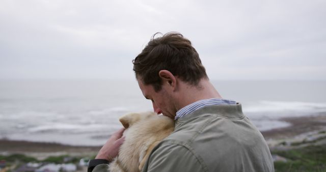 Man Embracing Dog on Sea Cliff, Reflecting Love and Nature - Download Free Stock Images Pikwizard.com