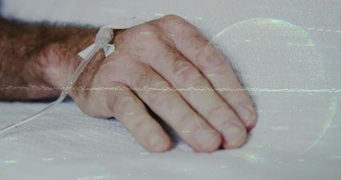 Senior hand resting with iv catheter in hospital setting