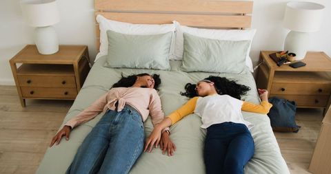 Friends relaxing in bedroom during moving day