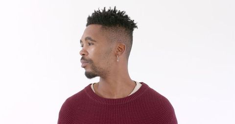 Thoughtful man in maroon sweater, deep contemplation indoors