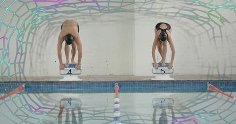 Competitive swimmers preparing on starting blocks, focus and precision