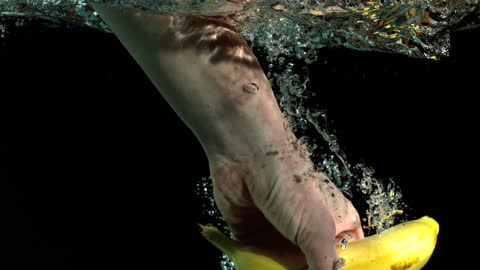 Hand Picking Banana Underwater in Bubbly Motion