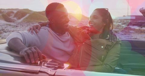 Beaming Couple on Adventure Embracing in Convertible