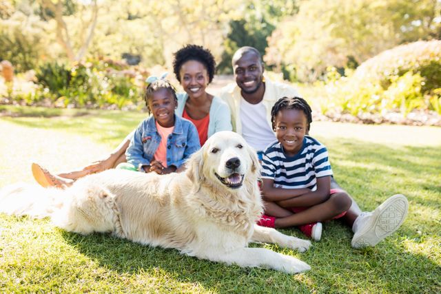 Family enjoying a sunny day at the park with their dog. Perfect for advertisements, family-oriented campaigns, pet care promotions, and lifestyle blogs.