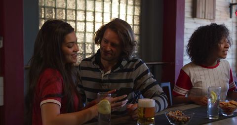 Friends In Cozy Pub Enjoying Drinks And Laughing